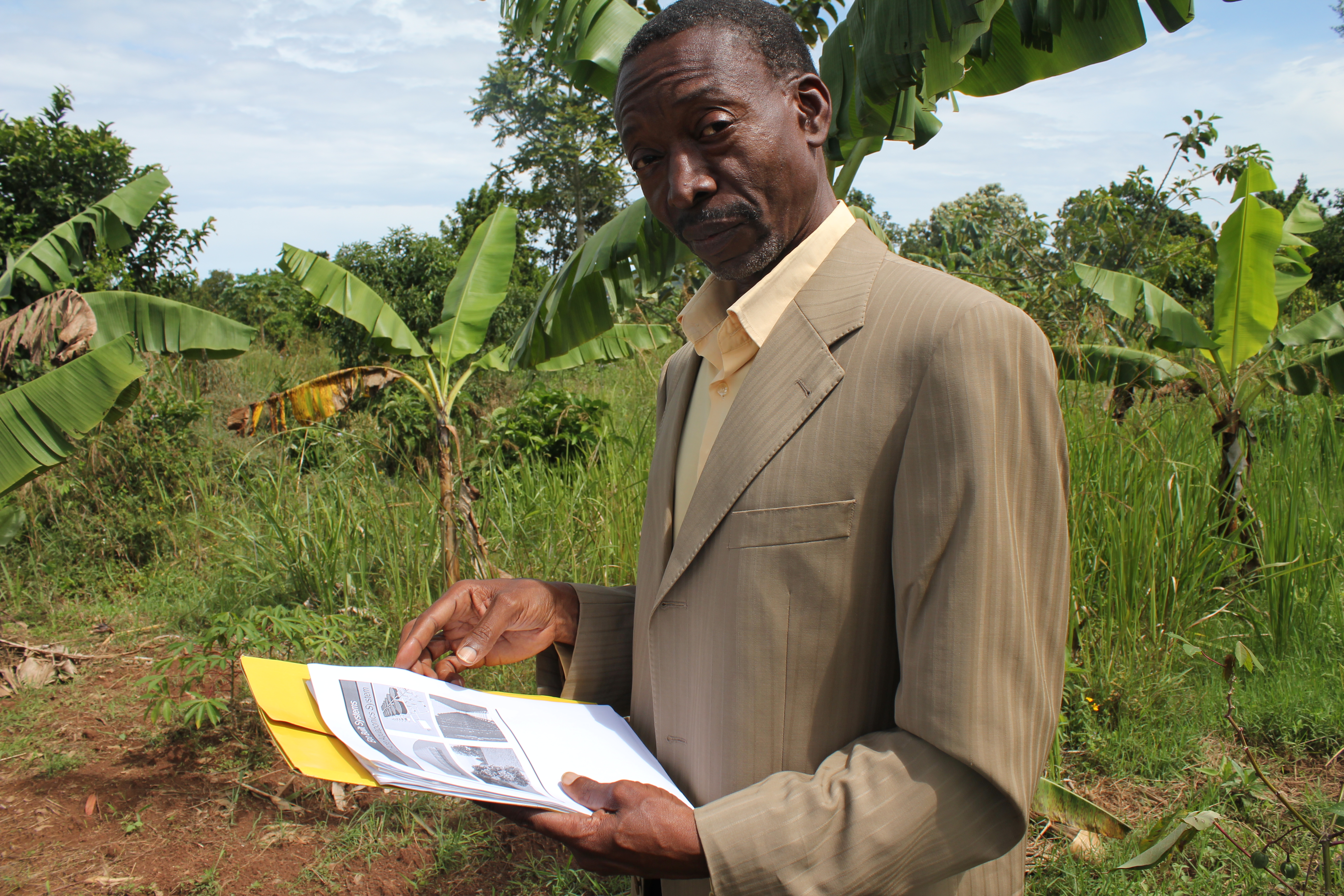 Charles Mulamata surveys a plot of land where he hopes to build an aquaponics facility.